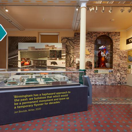 A display of objects relating to the city including a model of the city, sign from pub and artworks.