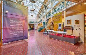 The Industrial Gallery, a large ornate gallery with ironwork arches and large glazed roof windows showing a display based on Made In Birmingham.