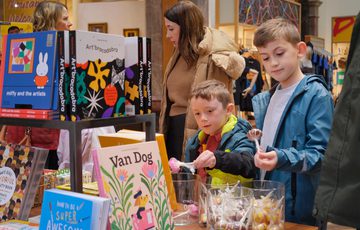 Two children looking at items on display in a shop.