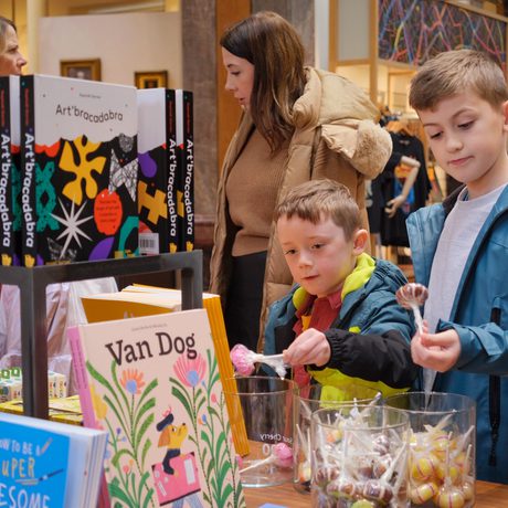 Two children looking at items on display in a shop.