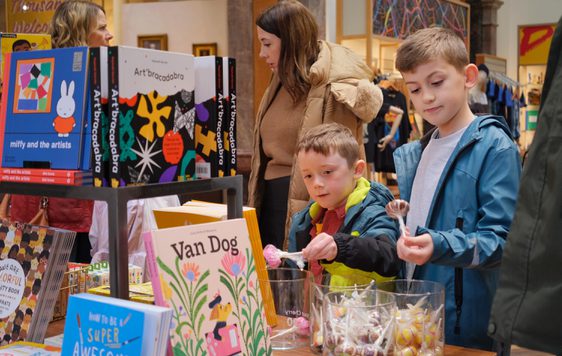 Two children looking at items on display in a shop.