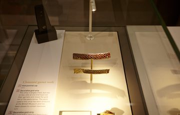 Close up of garnet and gold Staffordshire hoard fragments on display.