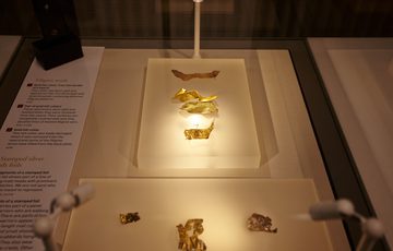 Close up of gold Staffordshire hoard fragments on display.