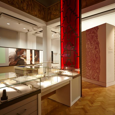 Gallery with display case in the centre and room to the side.