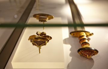 Real fragments from a sword handle alongside a replica sword.