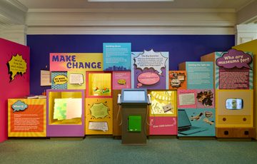 Close up of the Make Change display area with colourful cases feauting objects, TV screen and speech bubbles.