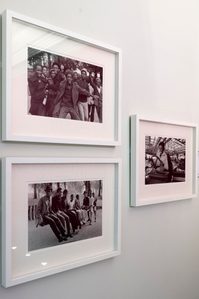Three black and white photographs on display on a wall.