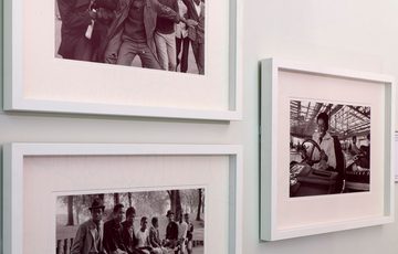 Three black and white photographs on display on a wall.