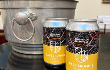 Two cans of drink with a ice bucket.