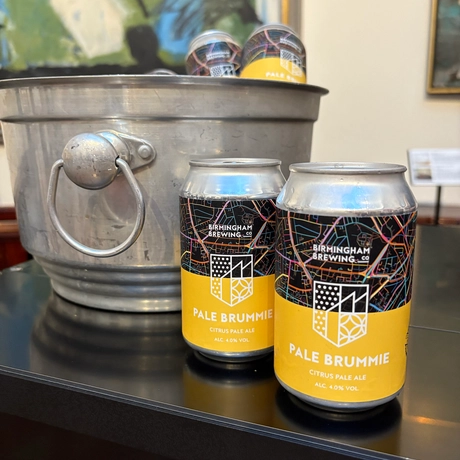 Two cans of drink with a ice bucket.