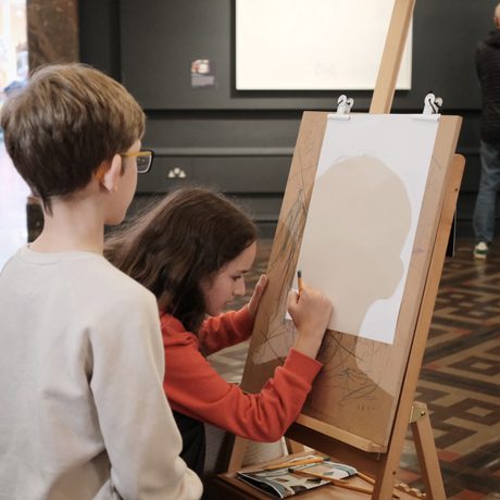 Two children drawing using an easel.