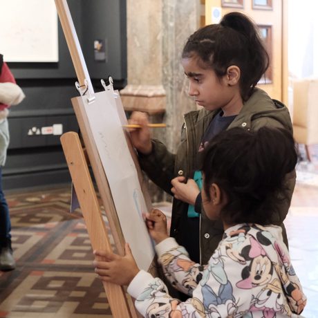Two children drawing using an easel.