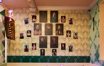 A series of portrait photographs on a wall.