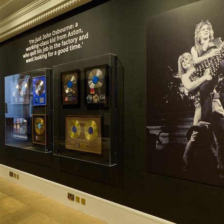 Display wall feating large black and white photo of Ozzy Osbourne and disc's in display cases.