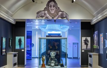 The end of the gallery with display case with large graphic of Ozzy Osbourne above.