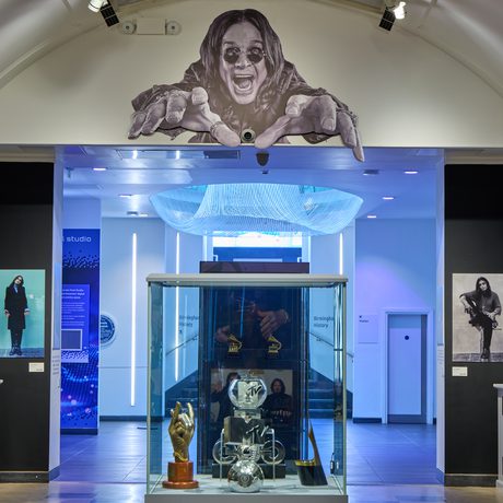 The end of the gallery with display case with large graphic of Ozzy Osbourne above.