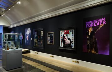 A view of the wall with a display case of awards to the side.