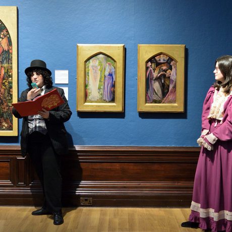 Two people in historical costume standing in an art gallery.