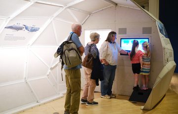 People inside a 3D model of an ancient animal.
