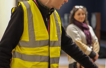 A staff member wearing a high vis vest.