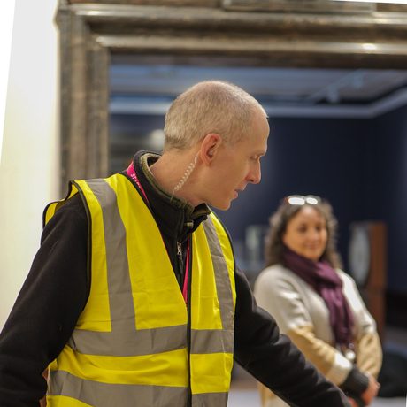 A staff member wearing a high vis vest.