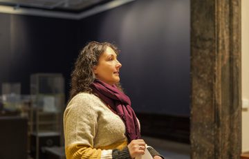 A staff member standing in a gallery doorway.