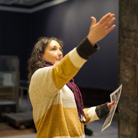 A staff member pointing up in the air to something out of the shot.