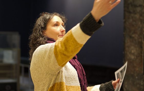 A staff member pointing up in the air to something out of the shot.