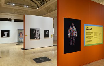 Photography exhibition featuring portraits of comedians in a spacious, well-lit gallery setting.