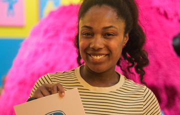 Smiling woman holds a Nokia mobile phone screen print.