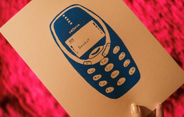A card with screen printed version of classic mobile phone displaying "Snobs" message.