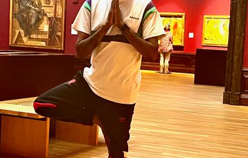 A person doing yoga in an art gallery.