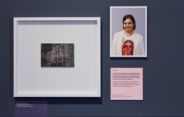Close up of a drawing and portrait photograph on display.