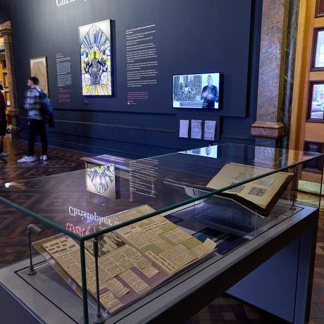 Display case with newspaper clippings in it and gallery display beyond.