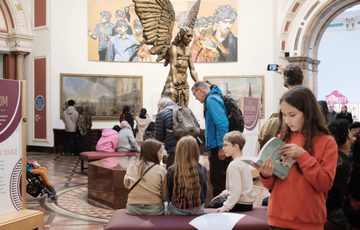 Lots of visitors sitting on benches in the Round Room.