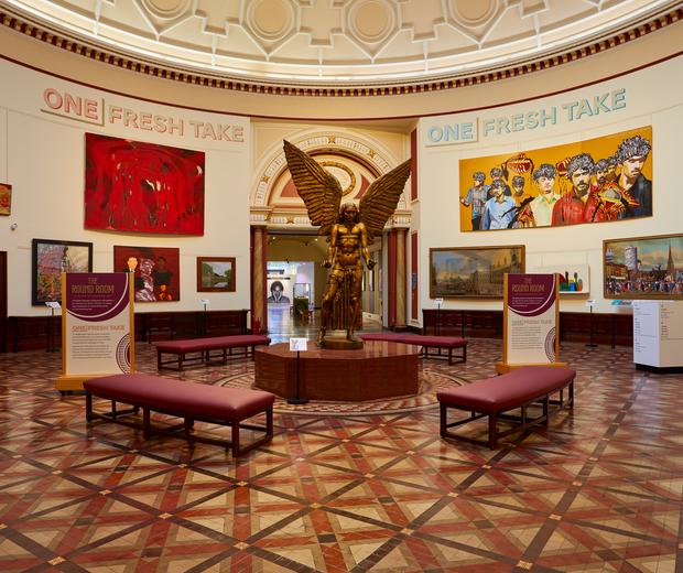 A view of the Round Room with large painting on the wall and a statue of Lucifer by Sir Jacob Epstein.