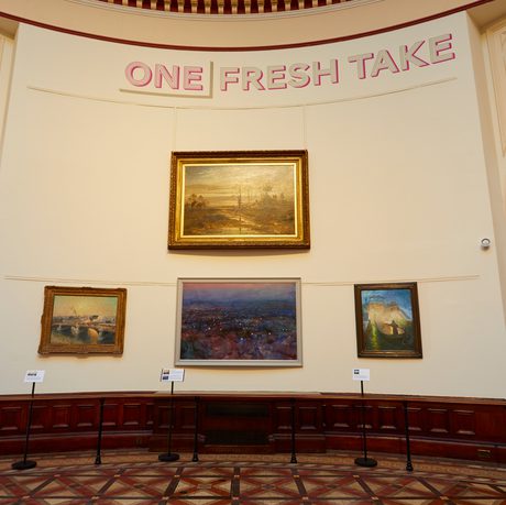 A group of four paintings hanging on the curved wall with the title 'One Fresh Take'.