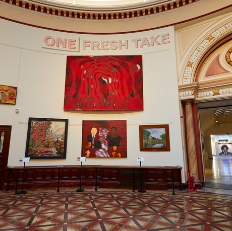 A group of four modern paintings hanging on the wall of the Round Room.