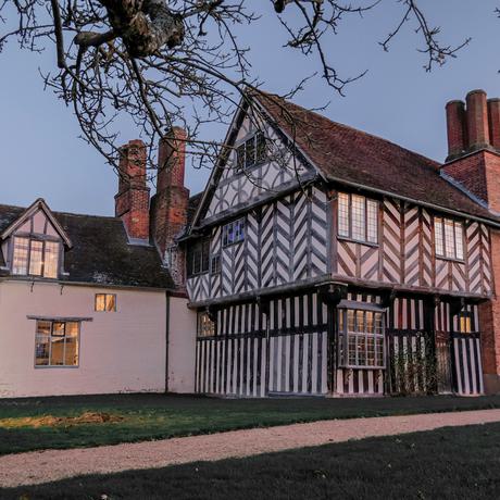 Exterior of the back of Blakesley Hall Tudor House, at dusk.