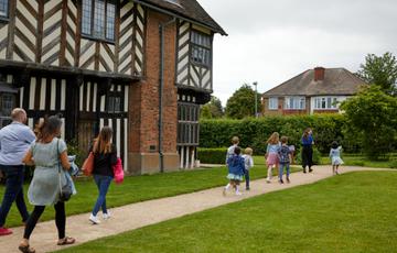 Family group walking along the path by Blakesley Hall.