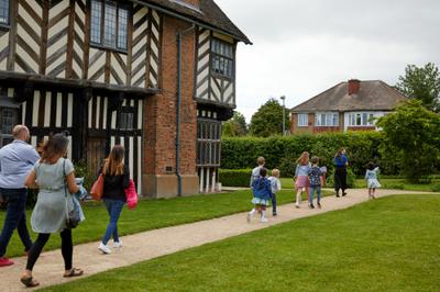 Family group walking along the path by Blakesley Hall.
