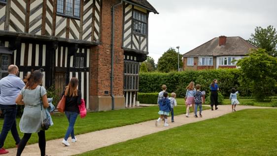 Family group walking along the path by Blakesley Hall.