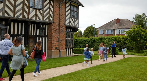 Family group walking along the path by Blakesley Hall.