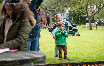 Two children standing outside in the garden.