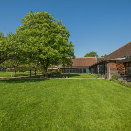 The green lawn area with a few trees. To the right is part of the visitor centre.