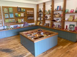 Small shop with wooden shelves displaying various packaged goods and jars.