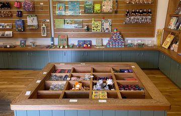 Small shop with wooden shelves displaying various packaged goods and jars.