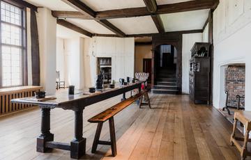 The Great Hall at Blakesley Hall with dining table in the centre.