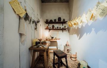 A small room with table, shelves and wooden seat.