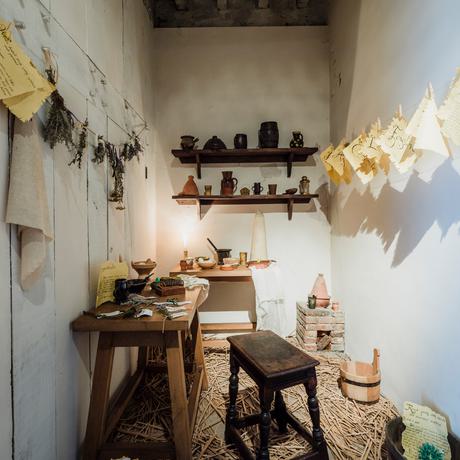 A small room with table, shelves and wooden seat.